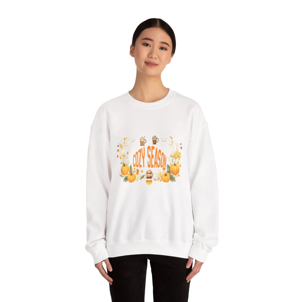 Woman wearing white Cozy Season sweatshirt with pumpkins and fall decorations on front