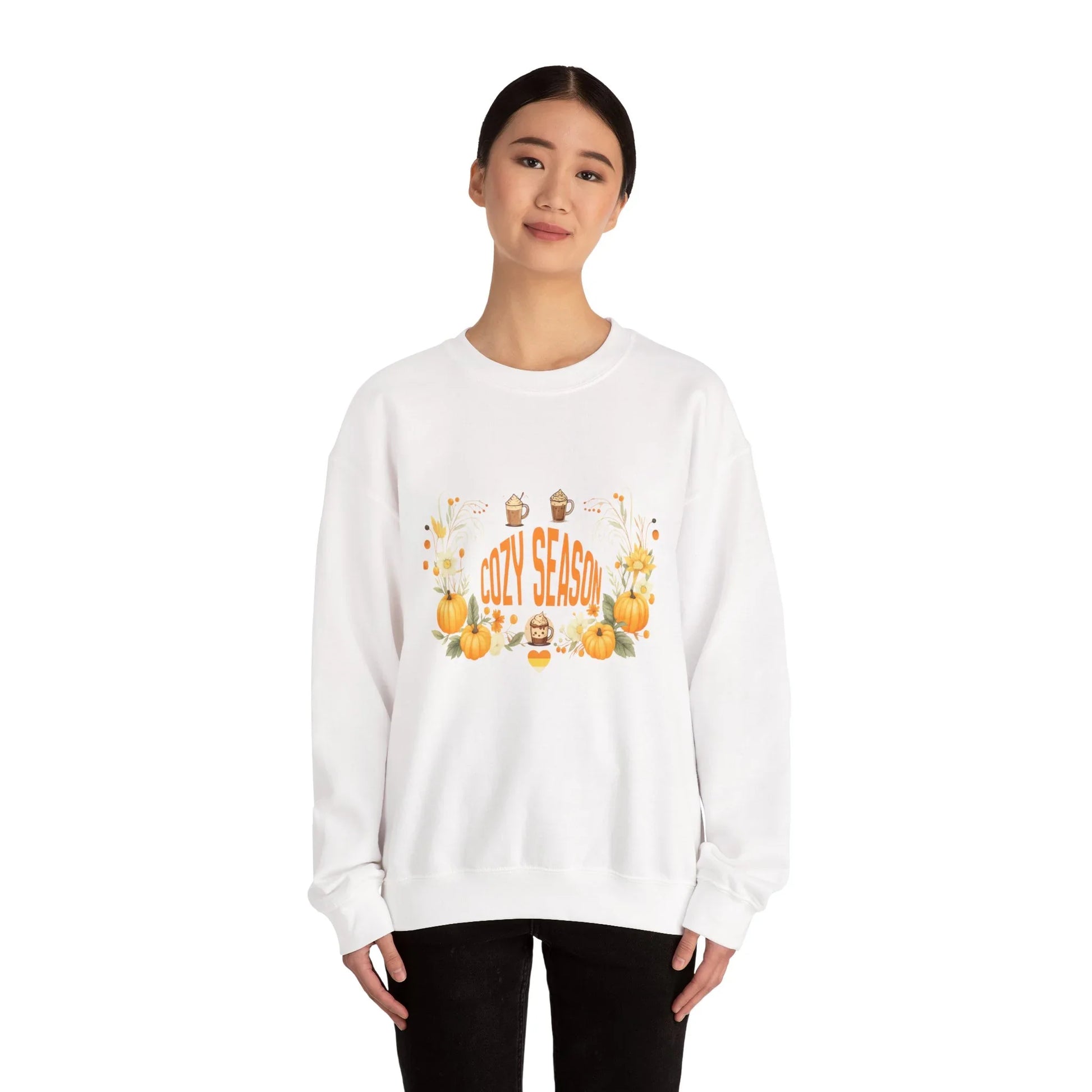 Woman wearing white Cozy Season sweatshirt with pumpkins and fall decorations on front