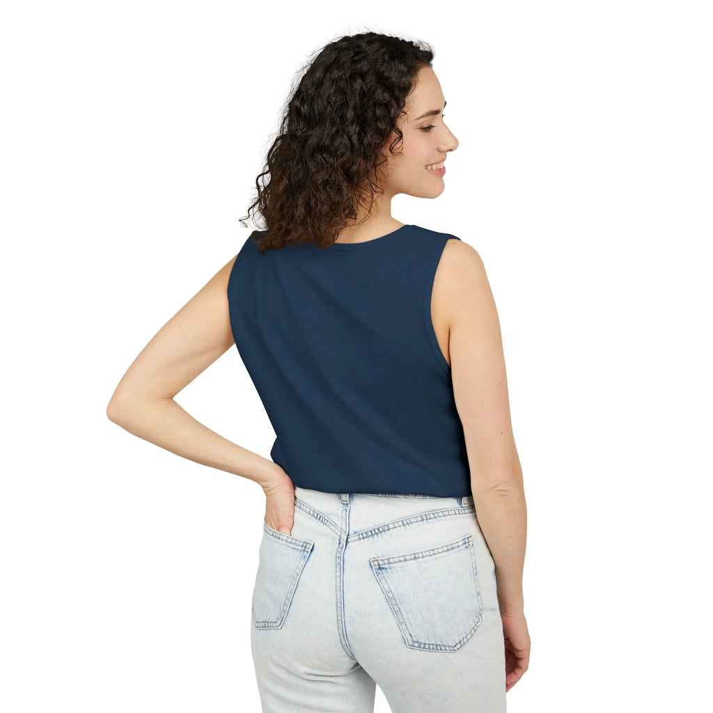 Woman wearing navy sleeveless top and light wash jeans, posing against white background