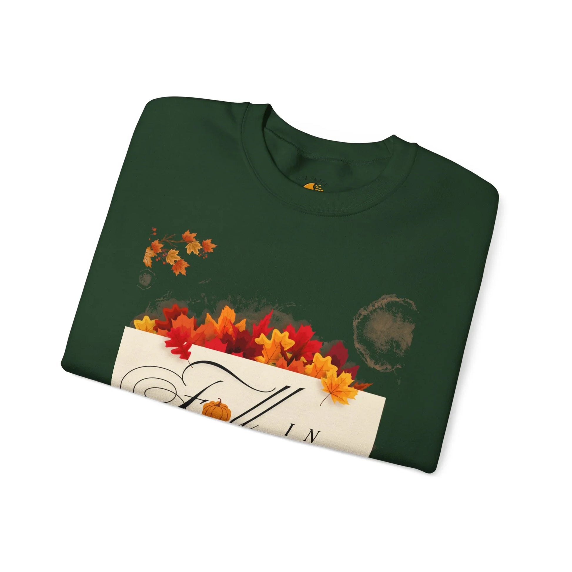 Folded green sweatshirt with fall leaves and 'Fall' text graphic, autumn apparel