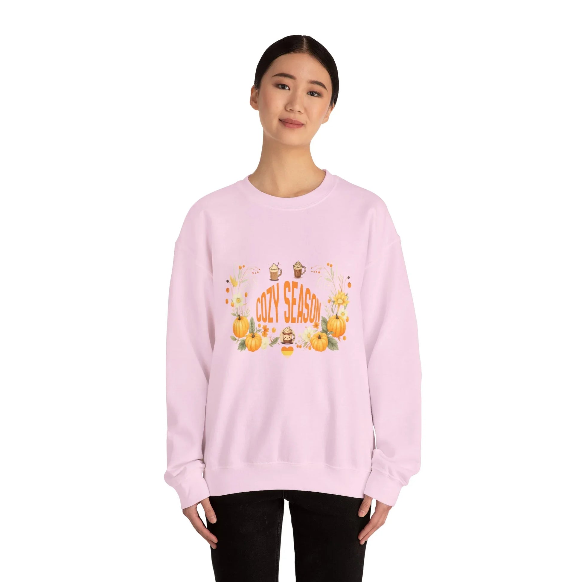 Woman in light pink cozy season sweatshirt with pumpkin and fall-themed design