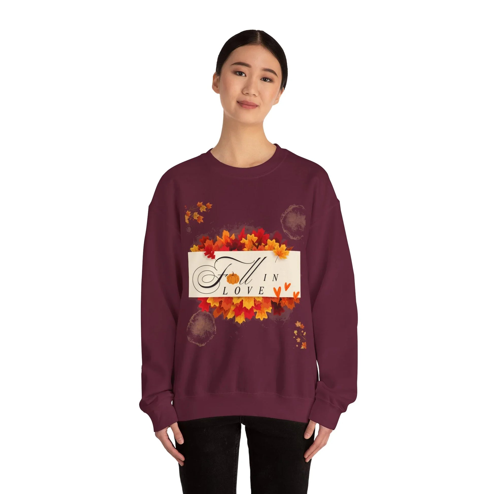 Woman wearing maroon Fall in Love sweatshirt with autumn leaves design on white background