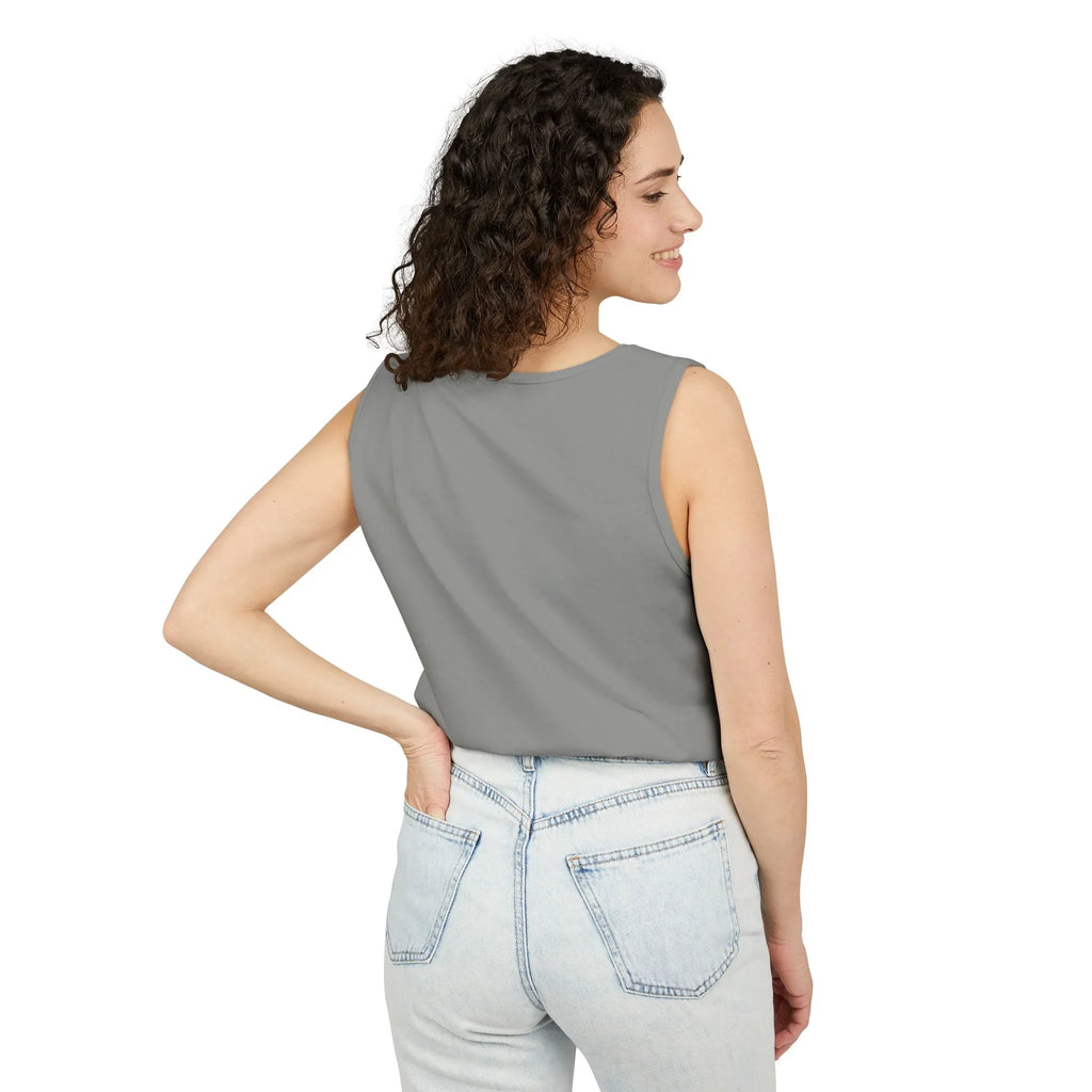 Woman in gray sleeveless top and light wash jeans posing with back to camera