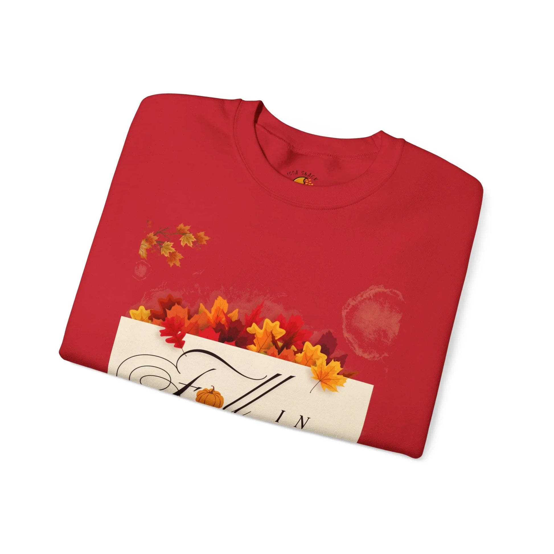 Red folded sweatshirt with autumn leaves and 'Fall' graphic, autumn-themed shirt design